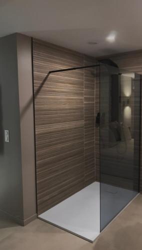 a glass shower door in a room with a couch at L instant précieux in Marseille