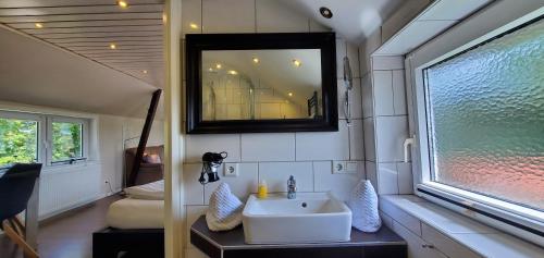 a bathroom with a sink and a mirror on the wall at Haus Königsstieg in Struckum