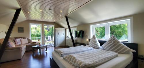 a bedroom with a bed and a couch and windows at Haus Königsstieg in Struckum