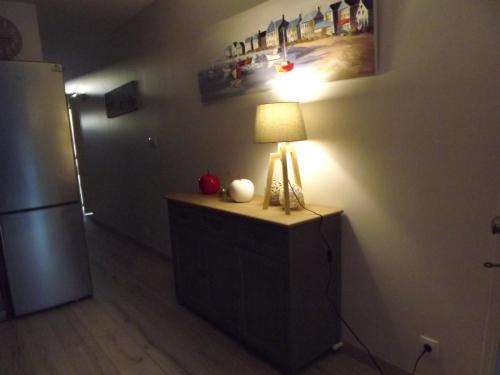 une lampe sur une commode dans une pièce avec un réfrigérateur dans l'établissement arcachon, à Arcachon
