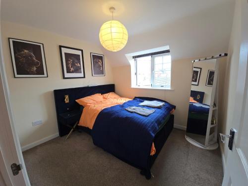 a bedroom with a blue bed and a mirror at Modern Beautiful Luxury Coach House Free Parking in Birmingham