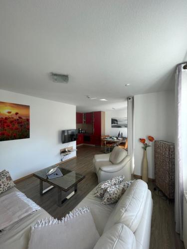 ein Wohnzimmer mit einer weißen Couch und einem Tisch in der Unterkunft Traumferienwohnung Ostseebad Baabe - Rügen in Baabe