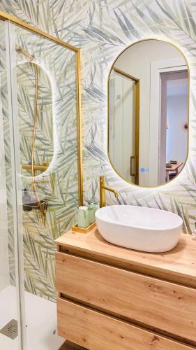 a bathroom with a white sink and a mirror at Apartamentos la Cárcava in Carcaboso