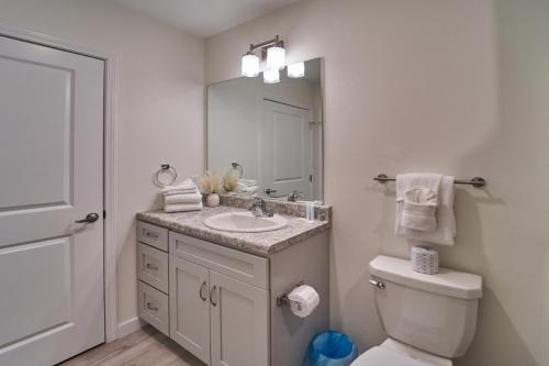 a bathroom with a sink and a toilet and a mirror at The Ruby 310 By Avada Properties in Pigeon Forge