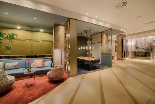 a living room with a blue couch and a table at NH Collection Milano Touring in Milan