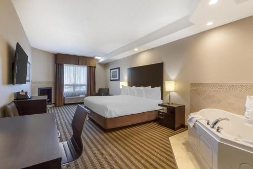 a hotel room with a bed and a bath tub at Best Western Plus Sherwood Park in Sherwood Park