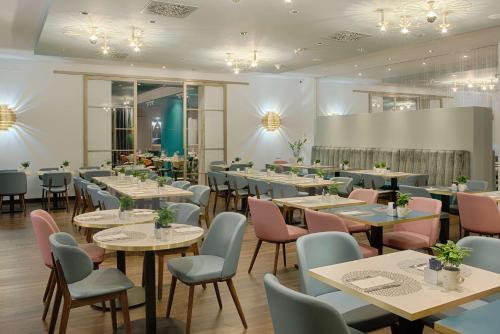Un comedor lleno de mesas y sillas en NH Collection Milano Touring, en Milán
