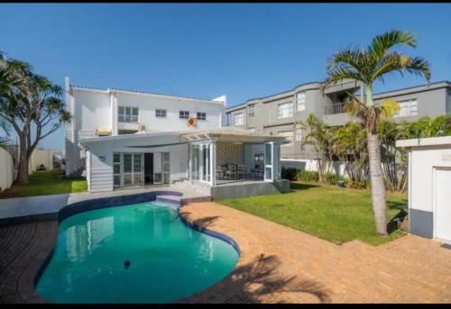 a house with a swimming pool in front of it at House on the Beach in Glenashley in Durban