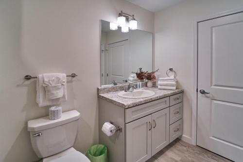 a bathroom with a sink and a toilet and a mirror at The Ruby 311 By Avada Properties in Pigeon Forge
