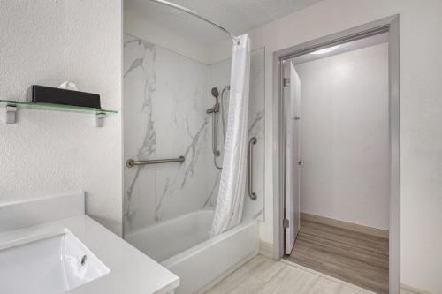 a bathroom with a shower and a tub and a sink at Best Western Greensboro Coliseum Inn in Greensboro