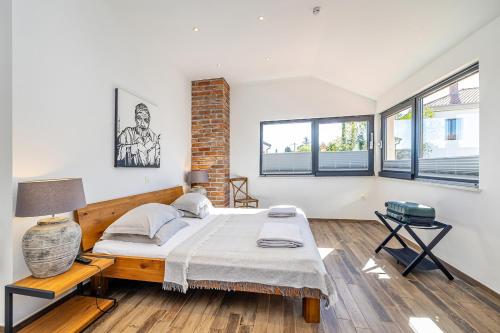 a bedroom with a bed and two windows at Villa Kvarner in Krk