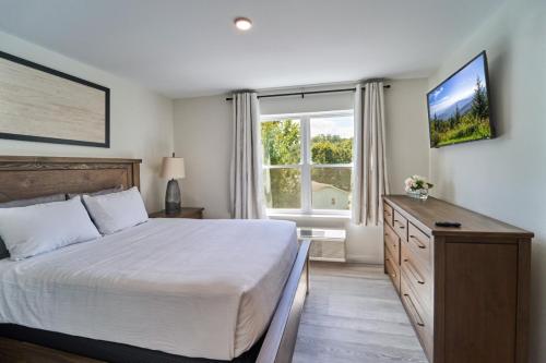 ein Schlafzimmer mit einem Bett und einem großen Fenster in der Unterkunft The Ruby 312 By Avada Properties in Pigeon Forge