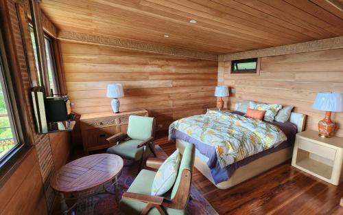 a bedroom with a bed and a table and chairs at Cloud Forest Lodge Boquete in Bajo Boquete
