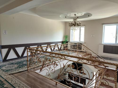 a spiral staircase in a house with a chandelier at Гостиница Шатыр in Saryaghash
