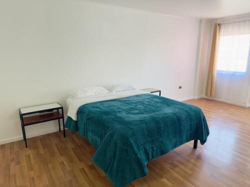 1 dormitorio blanco con 1 cama con manta verde en Hotel Atacama Copiapo, en Copiapó