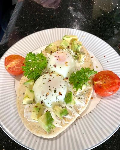 Un plato de comida con huevos y verduras encima. en Cullentra House, en Cushendall