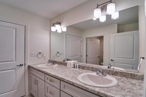 a bathroom with two sinks and a large mirror at The Ruby 315 By Avada Properties in Pigeon Forge