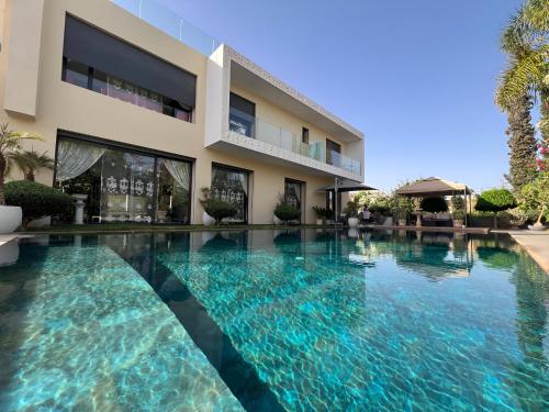 une piscine devant un bâtiment dans l'établissement Villa Fiori Luxury Italian Villa, Pool & Spa, Marrakech, à Douar bel Rhanodour