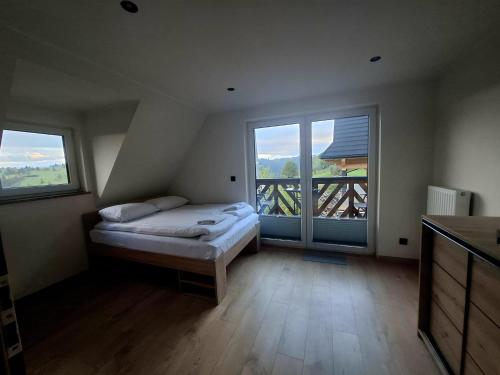 a bedroom with a bed and a large window at DreamHill in Bustryk