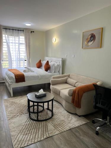 un salon avec un canapé et un lit dans l'établissement Favour cozy stay 24, à Nairobi