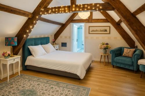 a bedroom with a bed and a blue chair at Les oiseaux de passage - chambre d hôtes, paisible in Gaillon