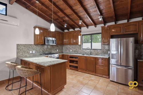 a kitchen with wooden cabinets and stainless steel appliances at Bright Beach Stay, Balcony, Patio & Steps to Beach in Refugio