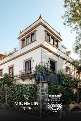 a white house with ivy growing around it at Pug Seal Polanco Anatole France in Mexico City
