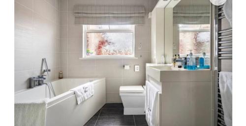 a white bathroom with a tub and a sink at Cullentra House in Cushendall