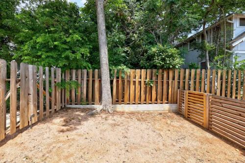 ein Holzzaun mit einem Baum davor in der Unterkunft Cozy studio in quiet area - Yard in Austin