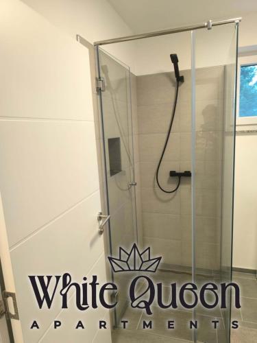a shower with a glass enclosure in a bathroom at White Quenn Apartments in Sanski most