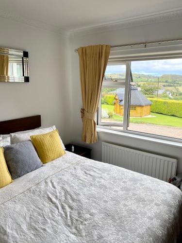 a bedroom with a bed and a large window at Cullentra House in Cushendall