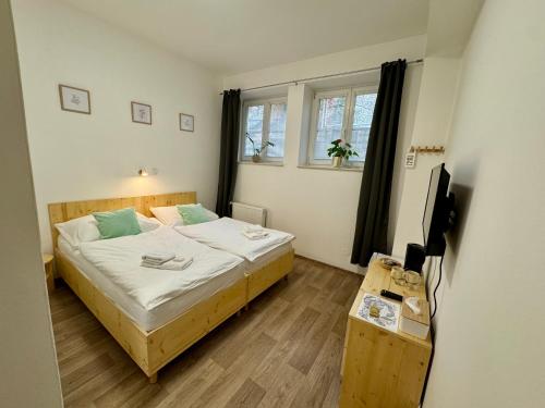 a small bedroom with a bed and a television at Hotel Rehavital in Jablonec nad Nisou