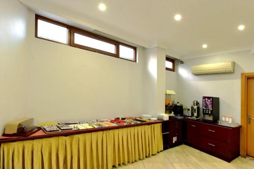 Un restaurante con una mesa con una cortina amarilla. en Hotel Öncü, en Estambul