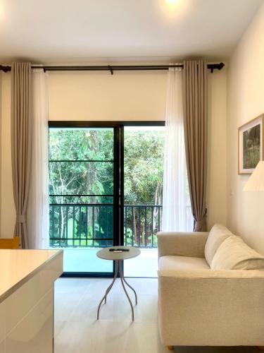 ein Wohnzimmer mit Sofa und Tisch in der Unterkunft The Whispering Palm Coconut Lane in Ko Phangan