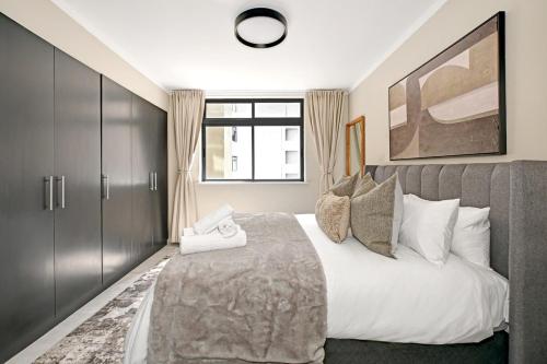 a bedroom with a large bed and a window at Soft Luxury 1BDR in trendy De Waterkant Nest in Cape Town