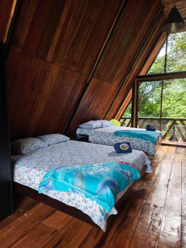 two beds in a room with wooden floors and windows at Quinta Túru in Colonia