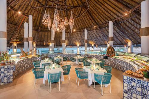 a dining room with tables and chairs and chandeliers at Royal Solaris Cancun - All Inclusive in Cancún