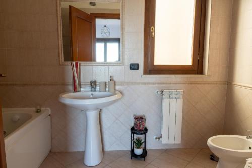 a bathroom with a sink and a toilet and a tub at appartamento con terrazzo vicino all'aeroporto di Fiumicino e alla fiera di Roma in Fiumicino Airport