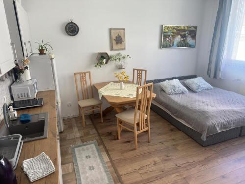 a bedroom with a bed and a table and chairs at Cichy Zaułek 8A in Brodnica