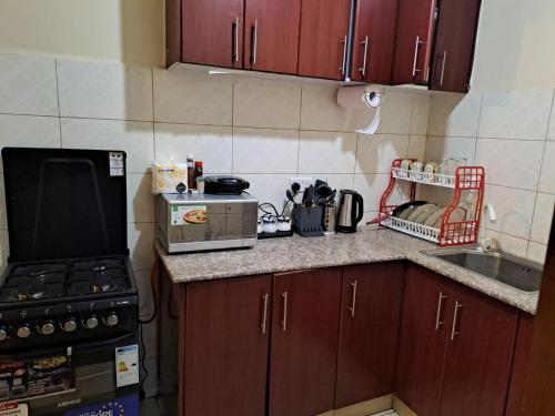 a small kitchen with a stove and a counter top at Tulia homes in Kanga