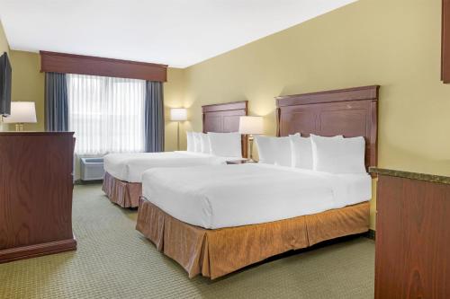 Una habitación de hotel con dos camas y dos ventanas. en Best Western Plus Grand-Sault Hotel & Suites, en Grand Falls
