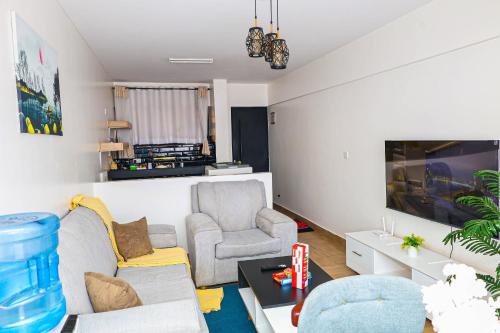 a living room with two chairs and a tv at Luxe Loft Kinoo in Kikuyu