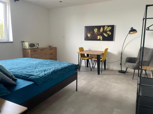 a bedroom with a bed and a table and chairs at Monstera III - industrial in Kolín