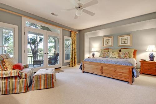 a bedroom with a bed and a chair and a window at OG02: 2 Ocean Green in Kiawah Island