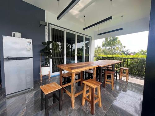una cucina con tavolo e sedie in legno e frigorifero di ฟ้ารีสอร์ต FAH Resort a Ban Nong Khang