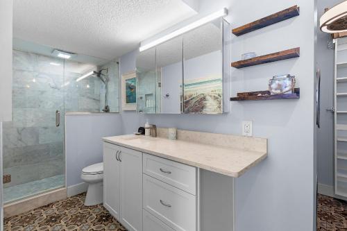 Un baño con ducha, lavabo e inodoro. en Golden Arms 602, en Chicken Island