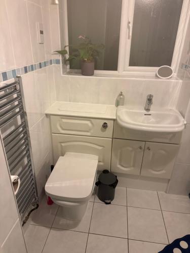 Un baño blanco con inodoro y lavabo. en Double bedroom, en Peterborough