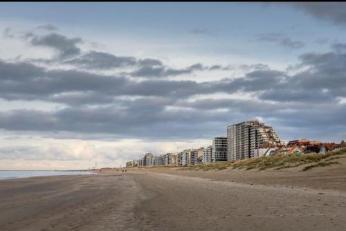 an empty beach with buildings on a cloudy day at Tantor 1 zeezicht in Nieuwpoort