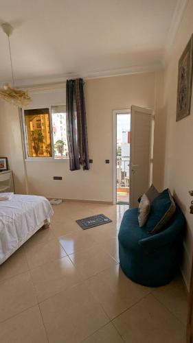 a bedroom with a bed and a blue couch at city centre house Near to souk Elhad agadir in Agadir