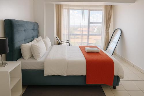 ein Schlafzimmer mit einem Bett mit einer bunten Decke darauf in der Unterkunft Luxe Loft Kinoo in Kikuyu